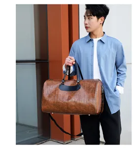 Detailansicht der braunen PU-Leder Reisetasche für Herren mit Kroko-Muster und Tragegriff.