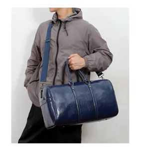 Vue détaillée d'un sac de voyage cylindrique élégant en cuir PU bleu porté par un modèle.