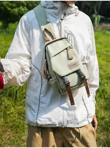 Detailansicht der Freizeittasche aus Nylon in Salbeigrün mit braunen Riemen und Schnallen.