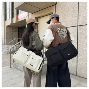 Detailansicht der Reisetasche mit mehreren Taschen, Front-Reißverschlussfächern und Schultergurt.