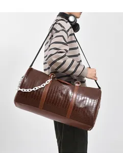 Nahaufnahme der braunen Krokodil-PU-Reisetasche mit Textur und weißer Dekokette.