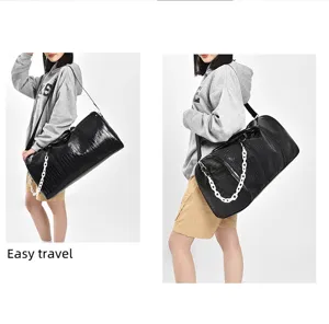 Detailansicht der großen schwarzen PU-Reisetasche mit stylischer weißer Kettendekoration.