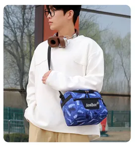Close-up detail view of the blue printed insulated cooler bag worn by a male model outdoors.