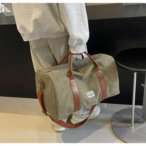 Grote canvas reistas met bruine lederen afwerking voor sport, fitness en dagelijks gebruik.