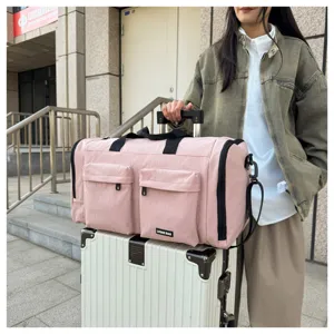 Rosa Reisetasche mit mehreren Taschen, verstellbarem Schultergurt und Griff.