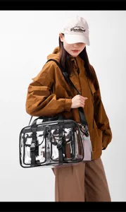 Detailansicht der klaren PVC-Reisetasche mit strapazierfähigen schwarzen Gurten und Schnallen.