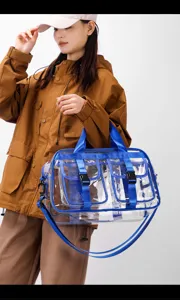 Transparente PVC Reisetasche mit blauen Gurten, geräumigem Fach und doppelten Vordertaschen.