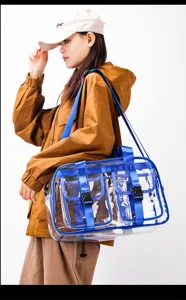 Transparente PVC Reisetasche für Damen, große wasserdichte Umhängetasche mit blauen Gurten.