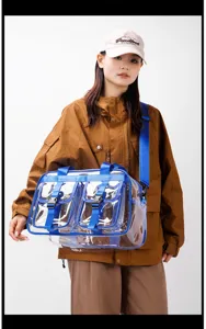 Transparente PVC Reisetasche Detail, blauer Gurt und Vordertaschen für modischen Stil.