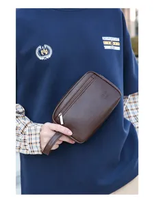 Primo piano della borsa da polso da uomo in pelle PU marrone con cerniera, astuccio da viaggio.