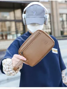 Dettaglio della pochette da viaggio da uomo in pelle PU marrone con pratica cerniera.