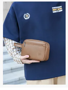 Primo piano dettagliato della borsa da toilette marrone in PU da uomo con cinturino da polso.