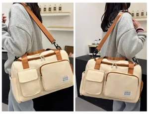 Detailansicht der großen Reisetasche mit mehreren Fächern und Kontrastriemen.