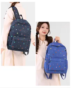 Vista detallada de la bonita mochila con estampado de fresas, bolsillo frontal y correas.