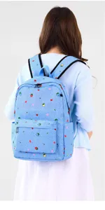 Vista detallada de cerca de una mochila azul con bonitos estampados de fresas y corazones.