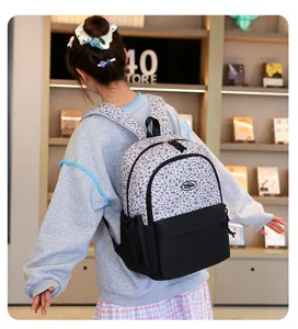 Mochila escolar para estudiantes con estampado de leopardo gris y diseño de fondo negro.