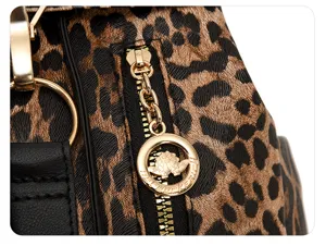 Close-up detail view of fashionable leopard print PU leather backpack with gold zipper and hardware.