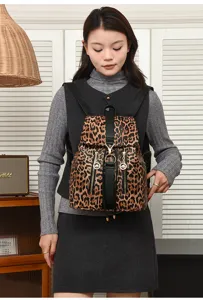 Stylish leopard print faux leather backpack with chic flap, metal ring accent and front pockets.