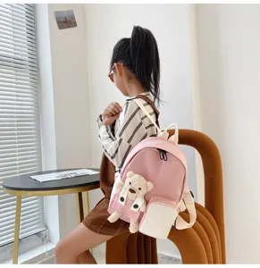 Zaino rosa per bambini con piccolo ciondolo a forma di orsetto, vista dettagliata ideale.