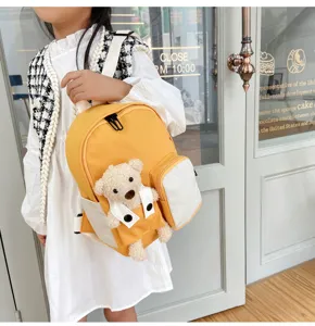 Vista dettagliata del simpatico zaino per bambini con orsetto, borsa scolastica gialla e bianca.