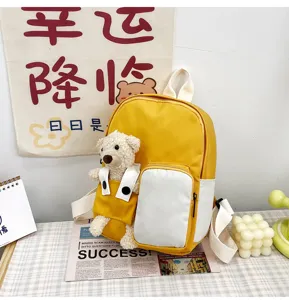 Zaino bambini giallo dettaglio con decorazione di orsetto peluche per viaggio.