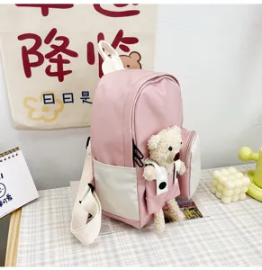 Vista dettagliata dello zaino rosa per bambini con un simpatico ciondolo in peluche e tasca.
