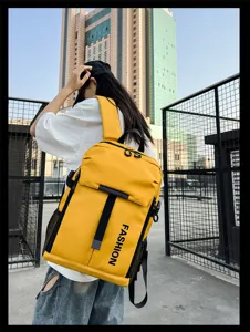 Städtische Detailansicht des großen gelben Reise-Rucksacks mit modischem Aufdruck.