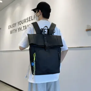 Detailed back view of a stylish black rolltop casual backpack worn by a model indoors.