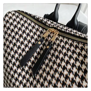 Gedetailleerd overzicht van een damesrugzak met houndstooth motief en rits.