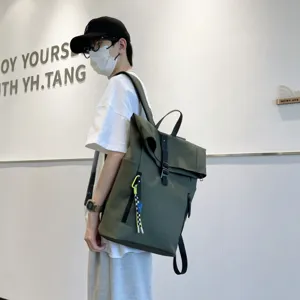 Detailed view of the Korean style casual army green roll-top backpack worn by model.