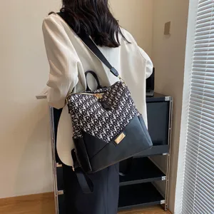 Stijlvolle damesrugzak met trendy monogram patroon en zwart leer, ideaal voor dagelijks gebruik.
