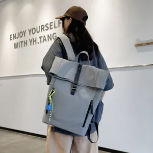 Detail view of a stylish grey casual backpack with roll-top design and large capacity.