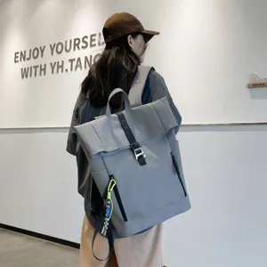 Grey rolltop casual backpack detail view showing large capacity and stylish design for daily use.