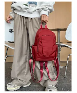 Detail van de mini wijnrode nylon rugzak, een veelzijdige crossbody en schoudertas.
