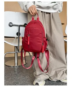 Gedetailleerd overzicht van rode nylon mini-rugzak, veelzijdige casual dagrugzak voor dames.