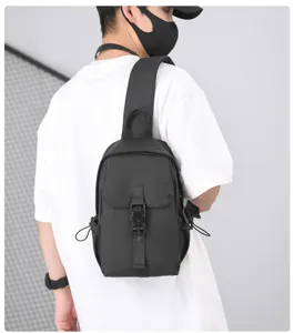 Dettaglio della borsa a tracolla nera impermeabile indossata dal modello, molto pratica.