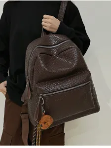 Ansicht des dunkelbraunen Lederrucksacks mit Flechtmuster, Schultergurten und Fronttasche.