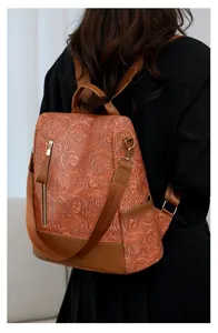 Detailansicht des braunen geprägten PU-Leder-Rucksacks mit exquisiter Blumenmuster-Textur.