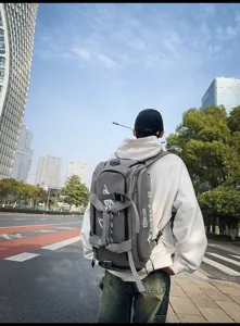 Gros plan détaillé du sac à dos de voyage gris multifonctionnel en milieu urbain.