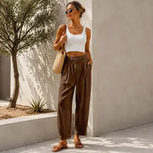 Fashionable woman wearing brown loose cropped harem pants with white ribbed tank top
