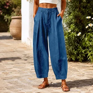 Outdoor lifestyle shot of blue loose-fitting harem pants with pleated front details.