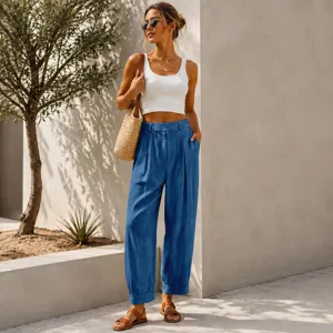Detail view of blue loose-fit cropped harem pants styled with a white crop top