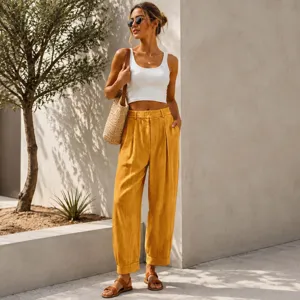 Stylish high-waisted yellow loose harem pants featured in a summer lifestyle shot.