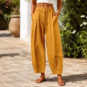 Detailed macro view of mustard yellow cropped harem pants with textured linen fabric.