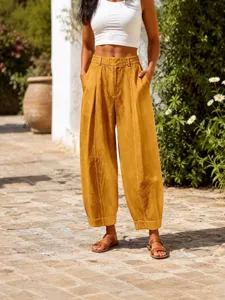 Women's stylish mustard yellow high-waisted loose harem cropped pants in outdoor setting