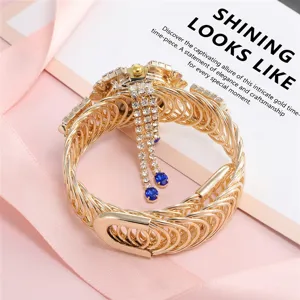 Macro view of vintage gold alloy bangle watch featuring rhinestones and elegant tassels.