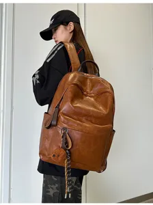 Vintage PU Leder Rucksack, retro braune Schultasche mit süßem Bär Anhänger Detail.