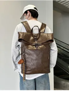 Detailed view of the dark brown PU leather roll top backpack worn by a model in urban setting