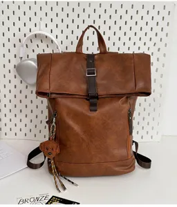 Vintage PU leather roll-top backpack for daily travel, casual brown laptop school bag with cute plush pendant.