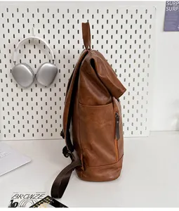 Side view detail of brown PU leather roll-top backpack showcased in a modern setup.
